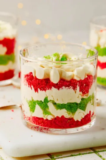 Mini Christmas Trifles with layers of green cake, red cake, and white cream cheese frosting