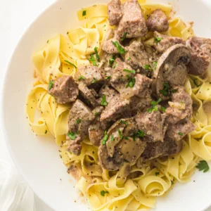 Plate of Crockpot Beef Stroganoff with Mushroom Soup Served Over Egg Noodles