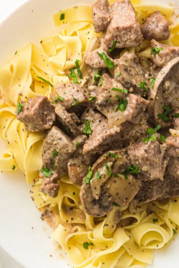 Plate of Crockpot Beef Stroganoff with Mushroom Soup Served Over Egg Noodles