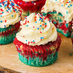 Unwrapped patriotic tie dye cupcakes with whipped icing.