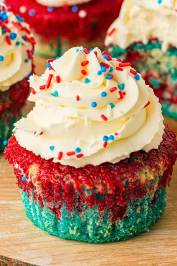 Unwrapped patriotic tie dye cupcakes with whipped icing.