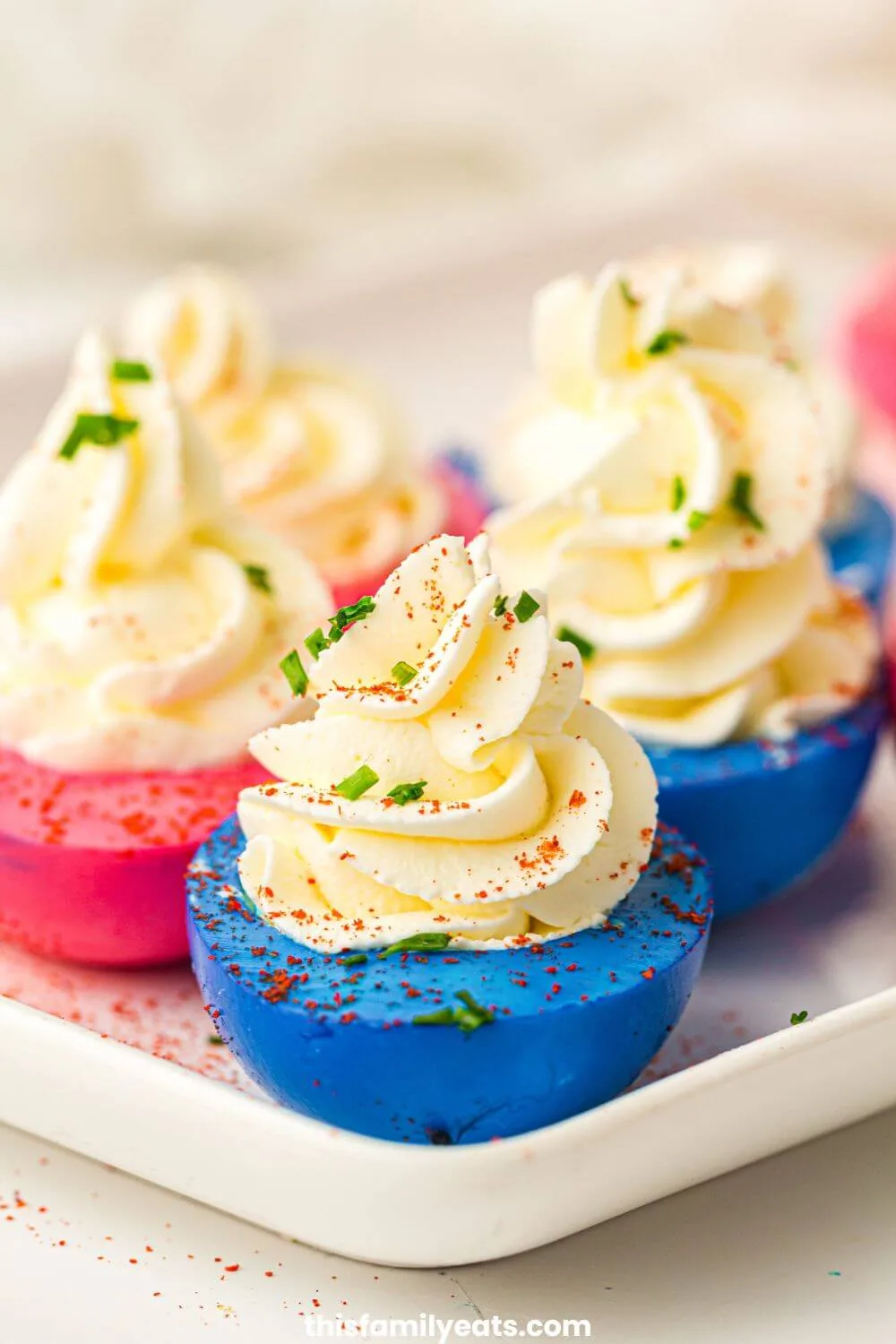 Patriotic red white and blue deviled eggs sprinkled with paprika.