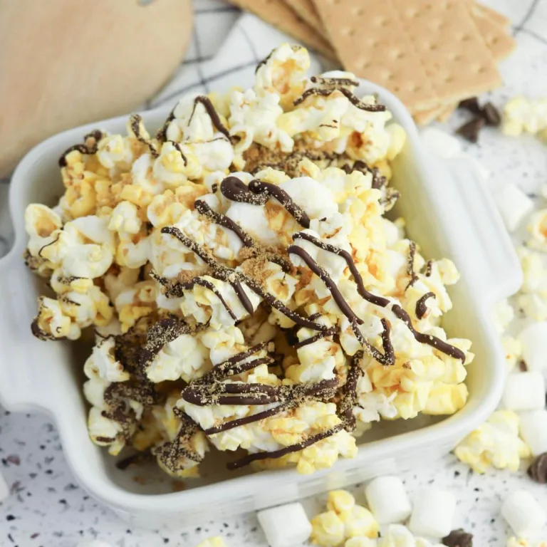 S'mores popcorn with chocolate drizzle in a white bowl.